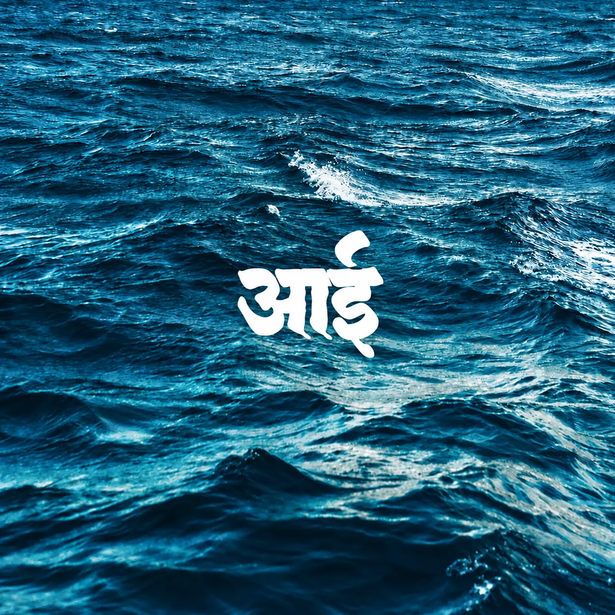 The word आई, mother in Marathi, in white over dark sea water